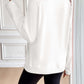 Woman wearing Ivy Lane Half Zip Raglan Sleeve Sweatshirt in white, shown from the back standing indoors.