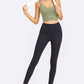 Model showcasing the Millennia Deep V-Neck Crop Sports Bra in olive green with black leggings, perfect for workouts.