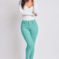 Woman wearing YMI Jeans Hyperstretch Mid-Rise Skinny Pants in teal, paired with white top and heels, showcasing versatile chic style