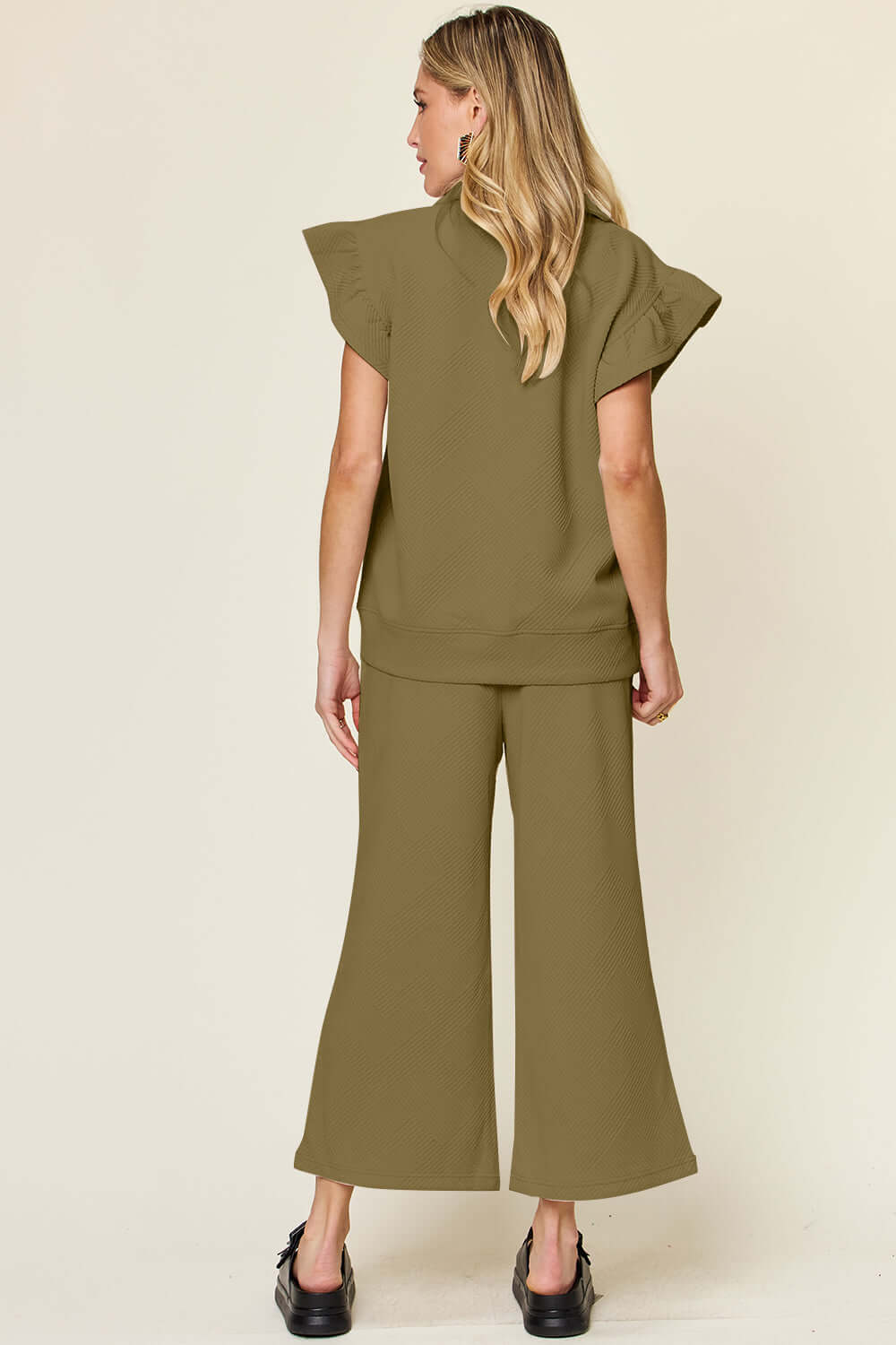 Woman modeling a Texture Ruffle Short Sleeve Top and Drawstring Wide Leg Pants Set from the back view.