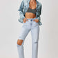 Model wearing button-up ombre washed jacket by Risen Jeans with distressed jeans and striped crop top. Trendy casual outfit.