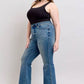 Stylish woman in black tank top and vintage wash jeans showcasing a flattering tummy control design.