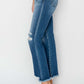 Woman modeling Risen Jeans frayed step hem ankle straight jeans, side view showcasing distressed details and chic ankle length.