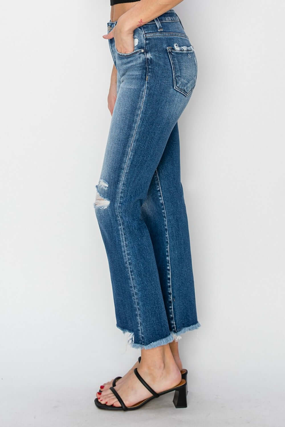 Woman modeling Risen Jeans frayed step hem ankle straight jeans, side view showcasing distressed details and chic ankle length.