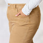 Woman wearing Risen jeans in beige with a flattering, high-waisted fit and pocket detail, paired with a white top.