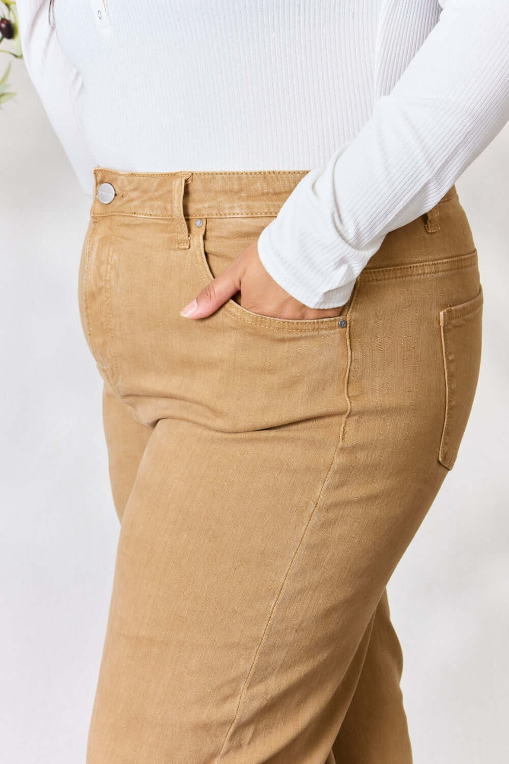 Woman wearing Risen jeans in beige with a flattering, high-waisted fit and pocket detail, paired with a white top.