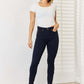 Woman wearing Garment Dyed Tummy Control Skinny Judy Blue Jeans with a white top, showcasing a flattering and slimming silhouette.