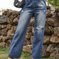 Woman wearing Bella Road distressed jeans with pockets and heels, showcasing a cool and edgy style, in a natural outdoor setting.