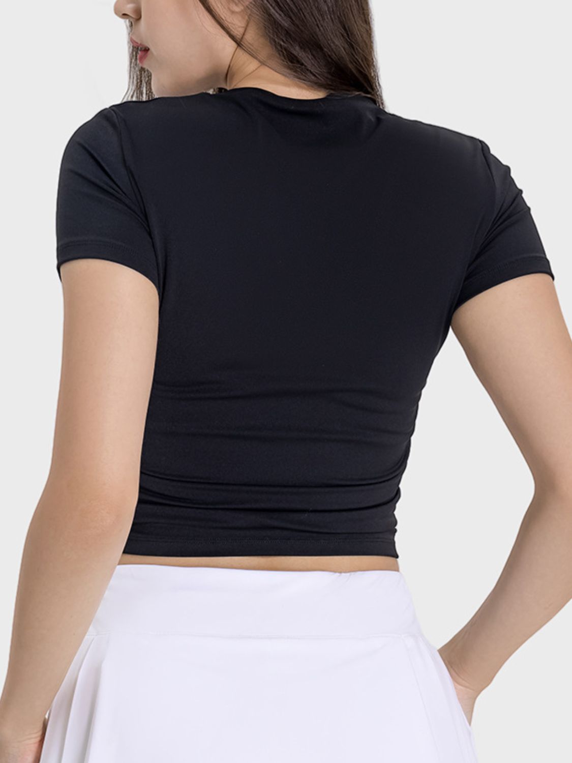 Woman wearing a black Millennia Ruched Round Neck Short Sleeve Active T-Shirt, showcasing the stylish ruched back design.