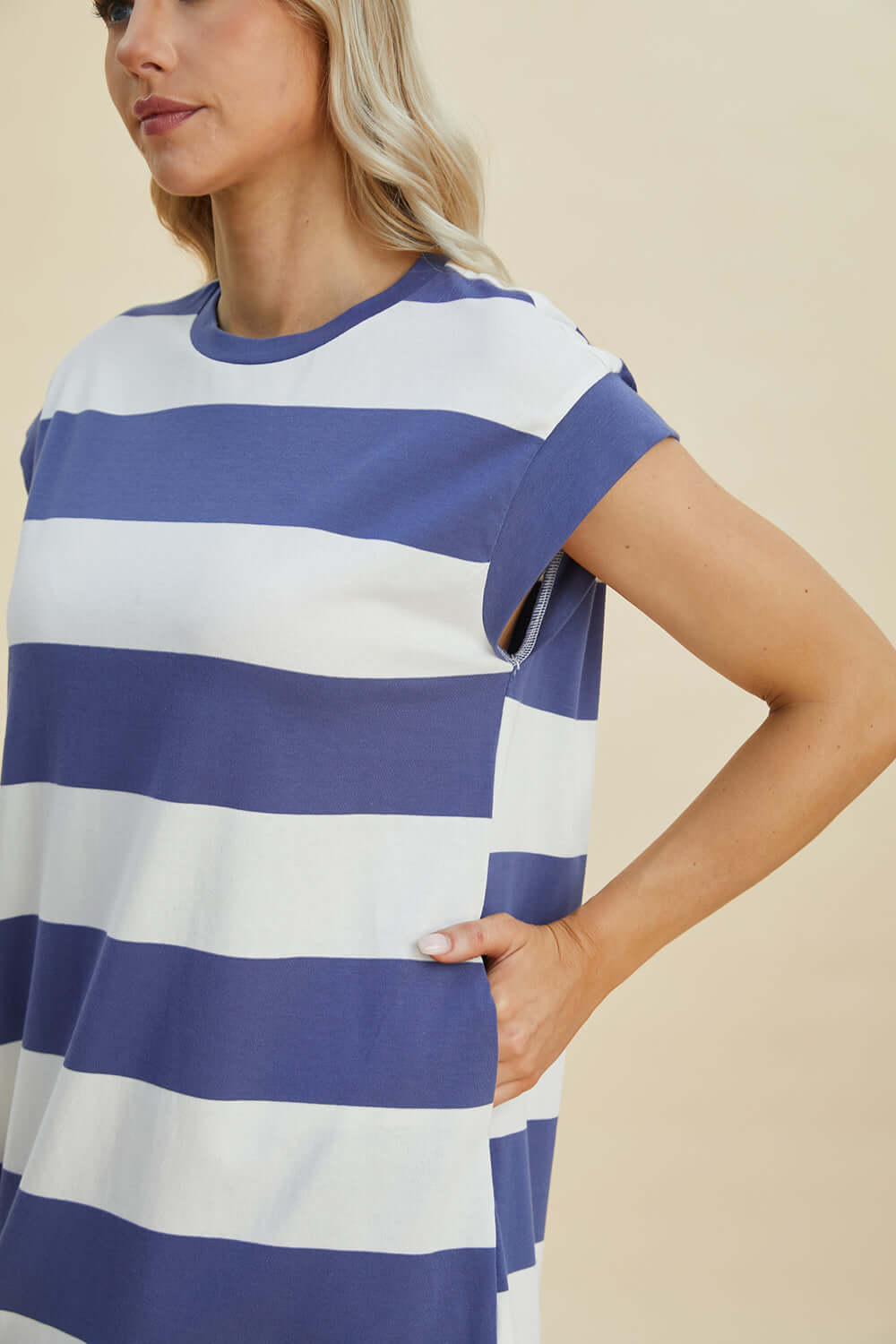 Woman wearing Basic Bae Full Size Striped Round Neck Cap Sleeve Mini Dress in blue and white stripes, showcasing side pocket detail.