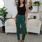 Stylish woman wearing FAM-FAM high waist skinny pants with decorative buttons in chic living room setting.