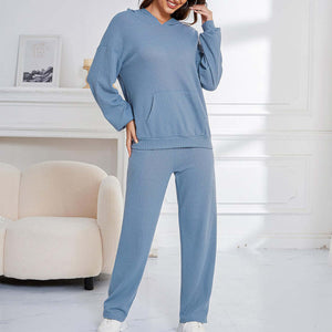 Woman in light blue Bella Road hoodie and pants set, pocketed, perfect for lounging. Cozy and stylish wardrobe essential.