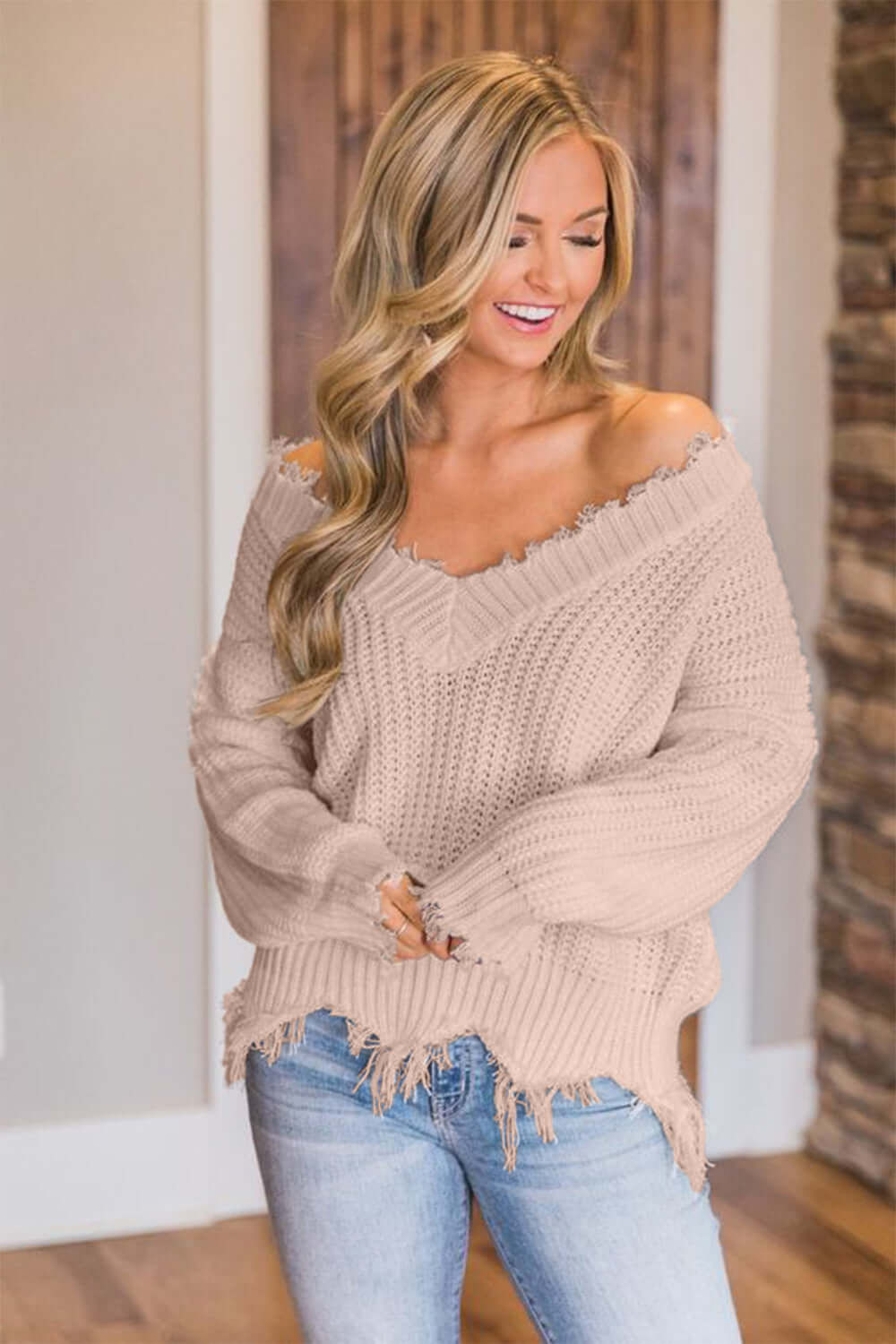 Woman wearing Bella Road Frayed Hem Dropped Shoulder Sweater in beige, showcasing its playful and stylish design.