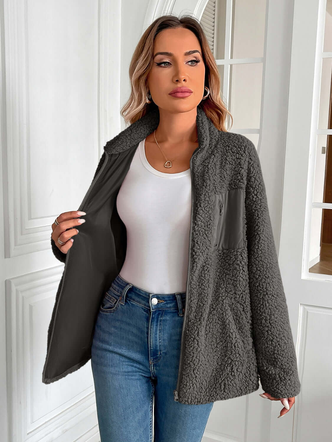 Woman wearing Ivy Lane Zip Up Long Sleeve Fuzzy Jacket in monochrome, showing cozy style and pockets. Perfect for chilly days.