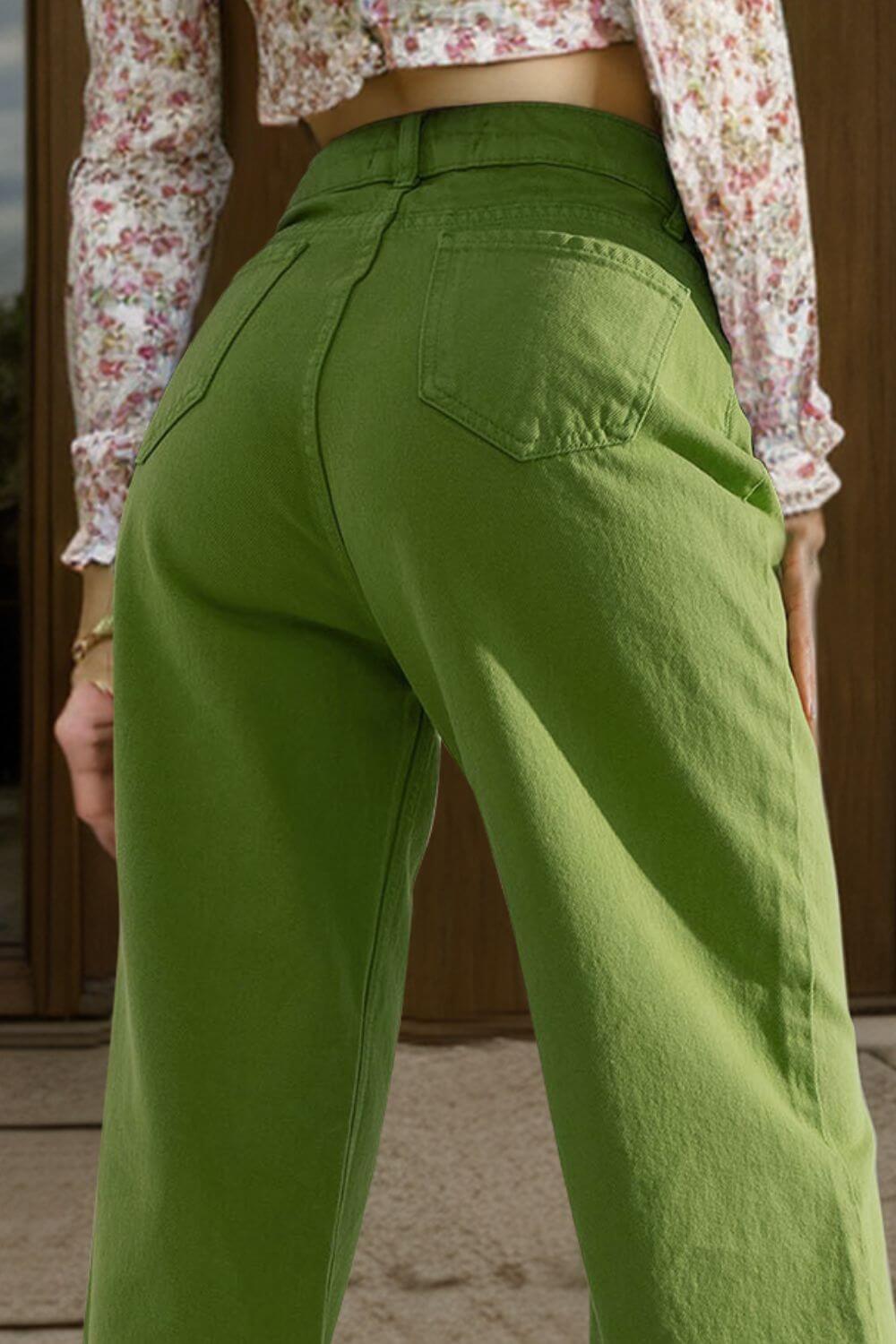 Woman wearing green wide leg jeans with pockets, shown from the back, paired with a floral top.