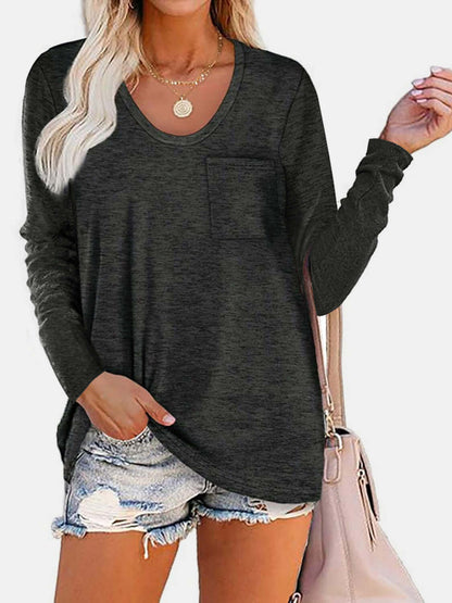 Woman wearing Bella Road round neck long sleeve T-shirt in dark gray with a pocket, paired with distressed denim shorts and a beige handbag.