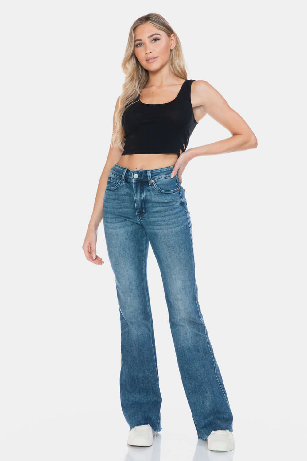 Woman wearing Judy Blue Full Size Tummy Control Vintage Wash Cut Hem Flare Jeans, showcasing a stylish and flattering look.