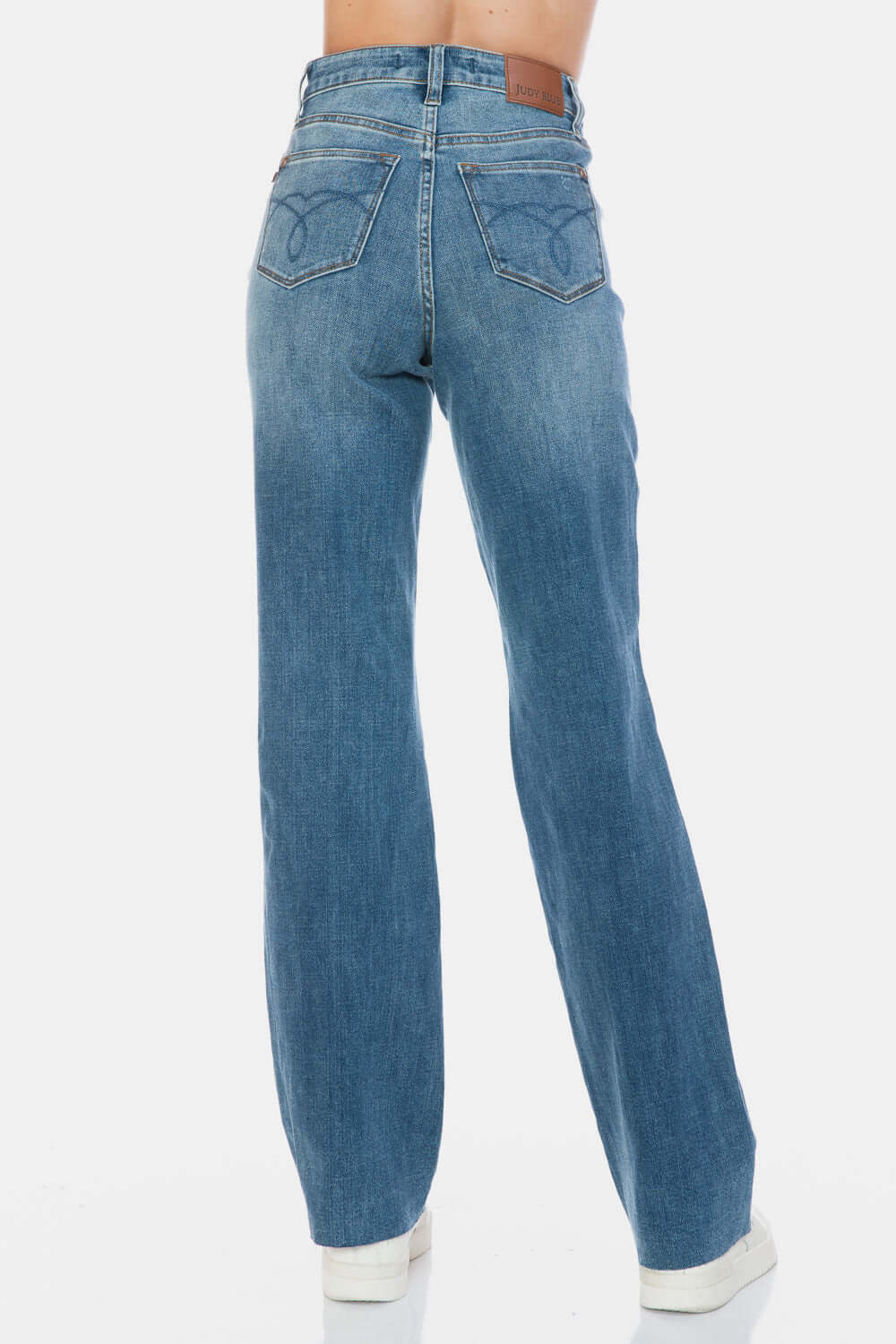 Judy Blue high-waist jeans with raw hem, showcasing back view and sleek silhouette, perfect for versatile styling.