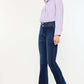 Woman wearing Kancan high-rise double waistband flare jeans in dark wash, paired with a striped blouse and flats.