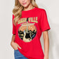 Woman wearing red graphic round neck short sleeve T-shirt with Nashville Tennessee guitar design, paired with blue jeans.