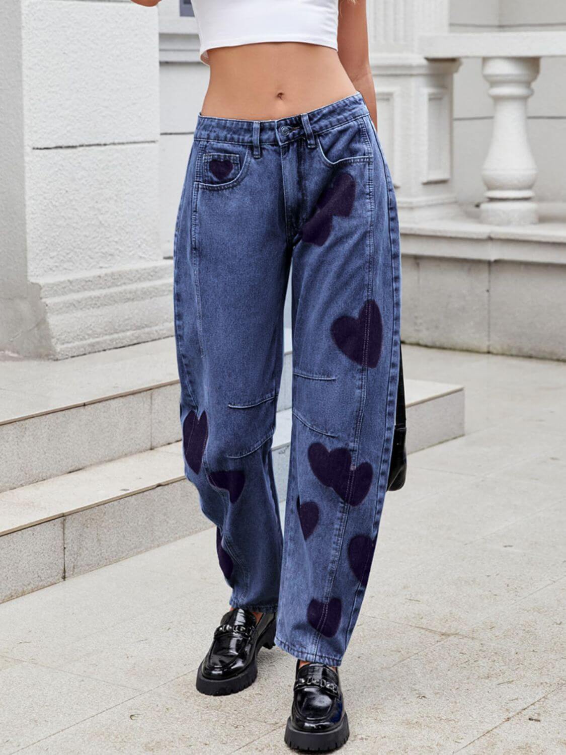 Stylish woman in Bella Road Denim Heart Mid Rise Jeans with heart design, showcasing a fun and trendy look.