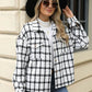 Woman wearing Bella Road Plaid Collared Neck Long Sleeve Jacket with sunglasses and black hat outside a building.