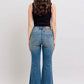 Model wearing Judy Blue mid rise tummy control vintage wash jeans from the back, showcasing retro style and flattering fit.