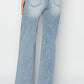 Back view of woman wearing High Rise Wide Leg Risen Jeans in light blue, showcasing the elongating and retro touch of the wide-leg design.