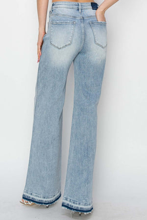 Back view of woman wearing High Rise Wide Leg Risen Jeans in light blue, showcasing the elongating and retro touch of the wide-leg design.