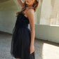 Woman wearing J.NNA mesh ruffle tube top swing dress, perfect for summer outings.