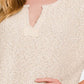 Beige short sleeve side slit sweater with textured knit fabric, modeled by a woman showing the neckline and part of the sleeve.