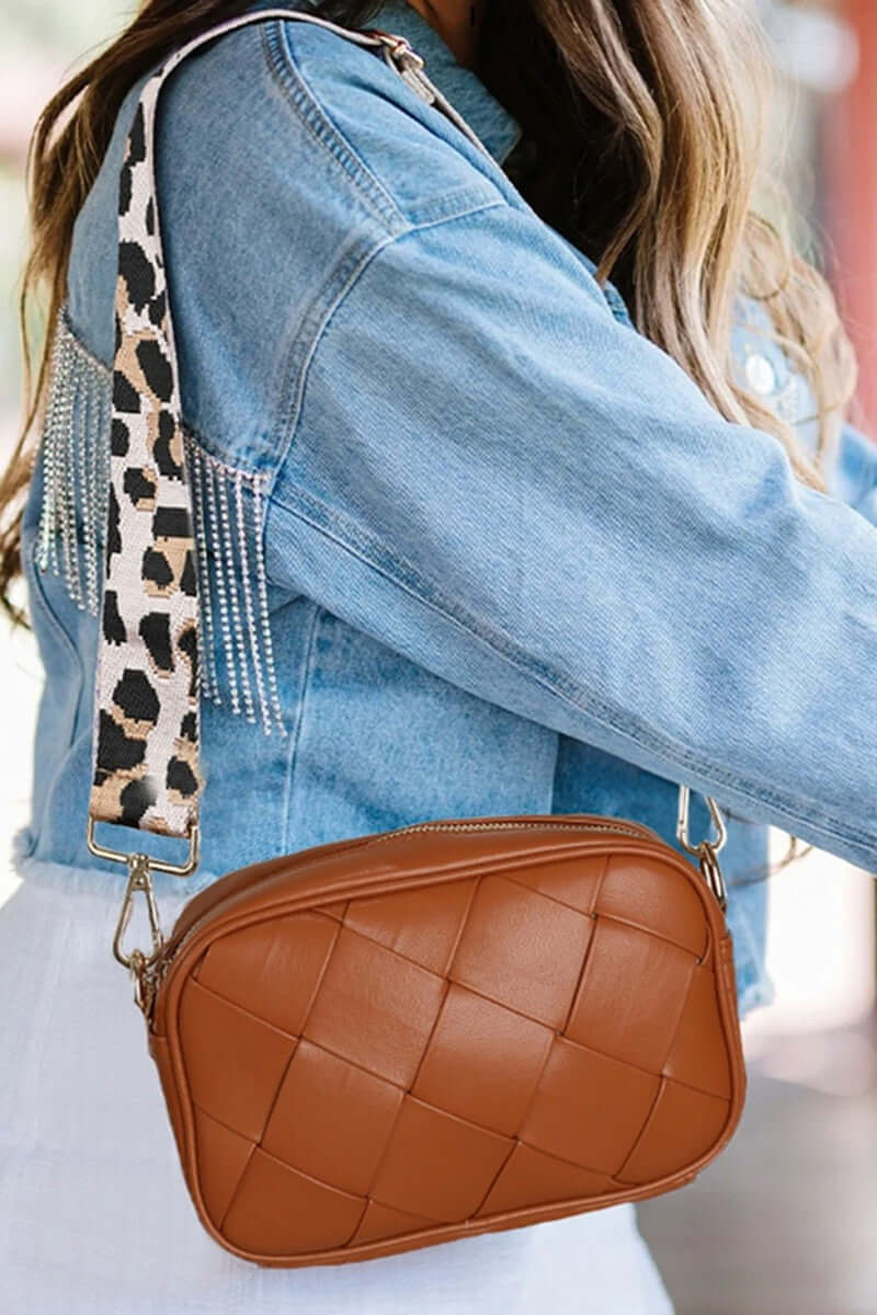 Stylish woman wearing a brown Cassette Woven Crossbody Bag with a trendy leopard print strap.