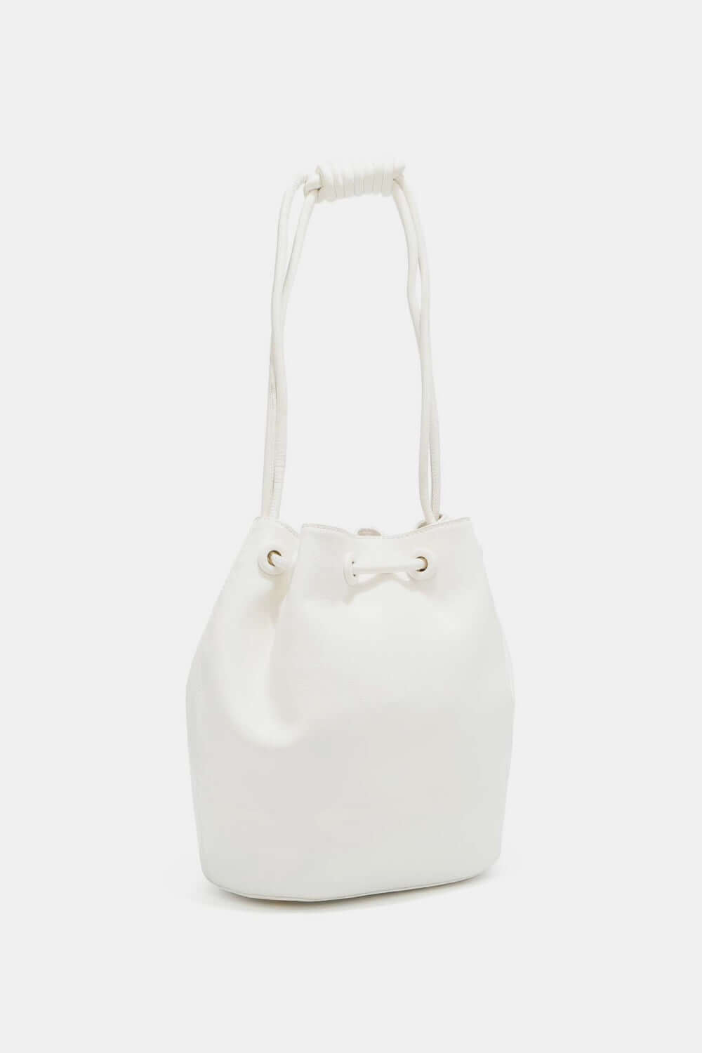 Nicole Lee USA Amy Studded Bucket Bag in white vegan leather with drawstring closure and metal feet, featuring a stunning stud and zipper design.