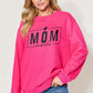 Woman wearing a pink "Mom Mode" letter graphic long sleeve sweatshirt, paired with blue jeans.