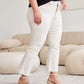 Woman wearing white high-waisted jeans with raw hem and wedges, showcasing a comfortable and stylish outfit ideal for any occasion.