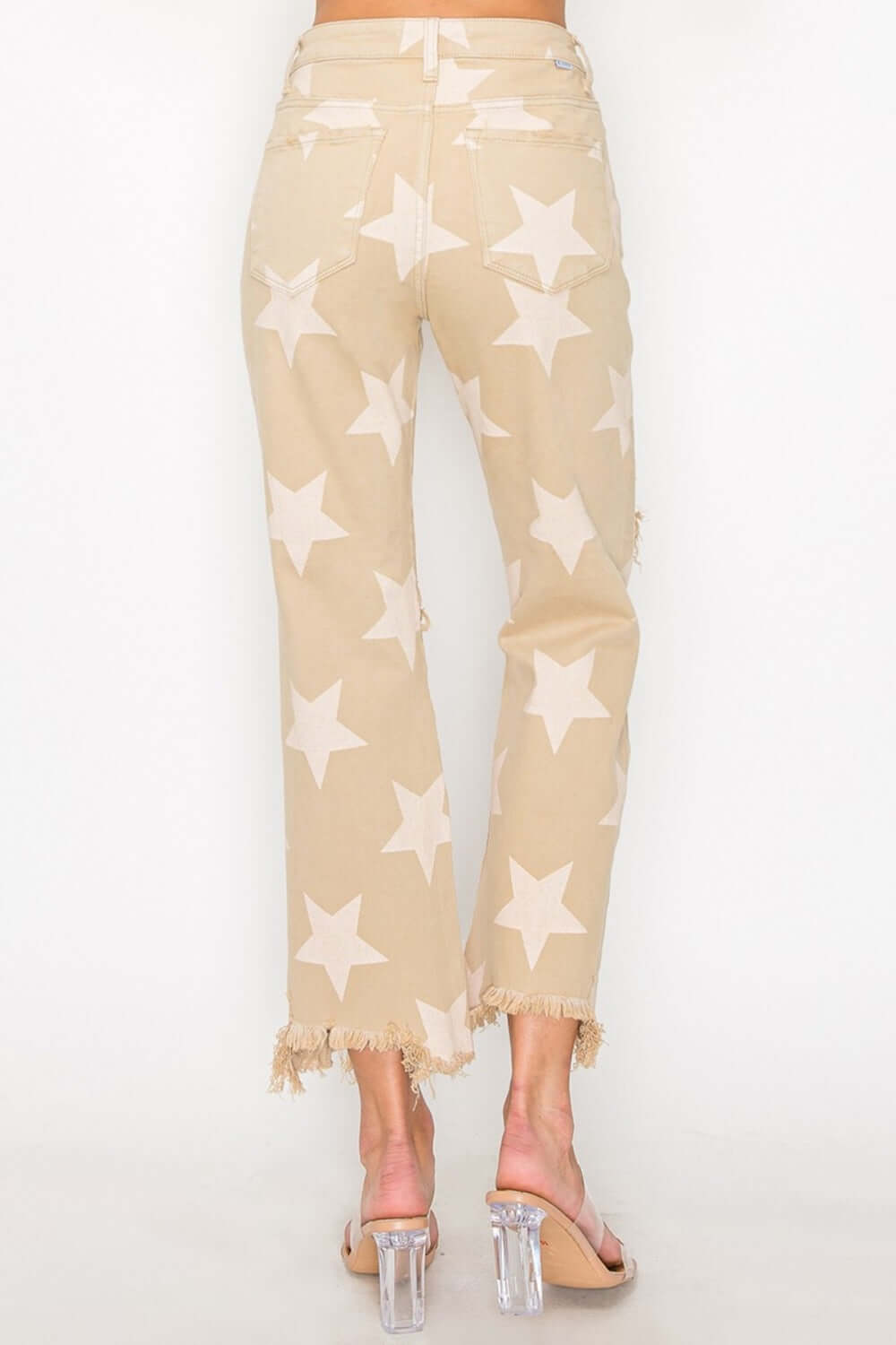 High rise jeans with star print and frayed hem, showcasing a chic and edgy style for a bold fashion statement.