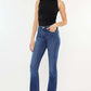 Woman wearing Kancan High Rise Slim Bootcut Jeans in medium stone wash with black top and heels, showcasing a stylish look.