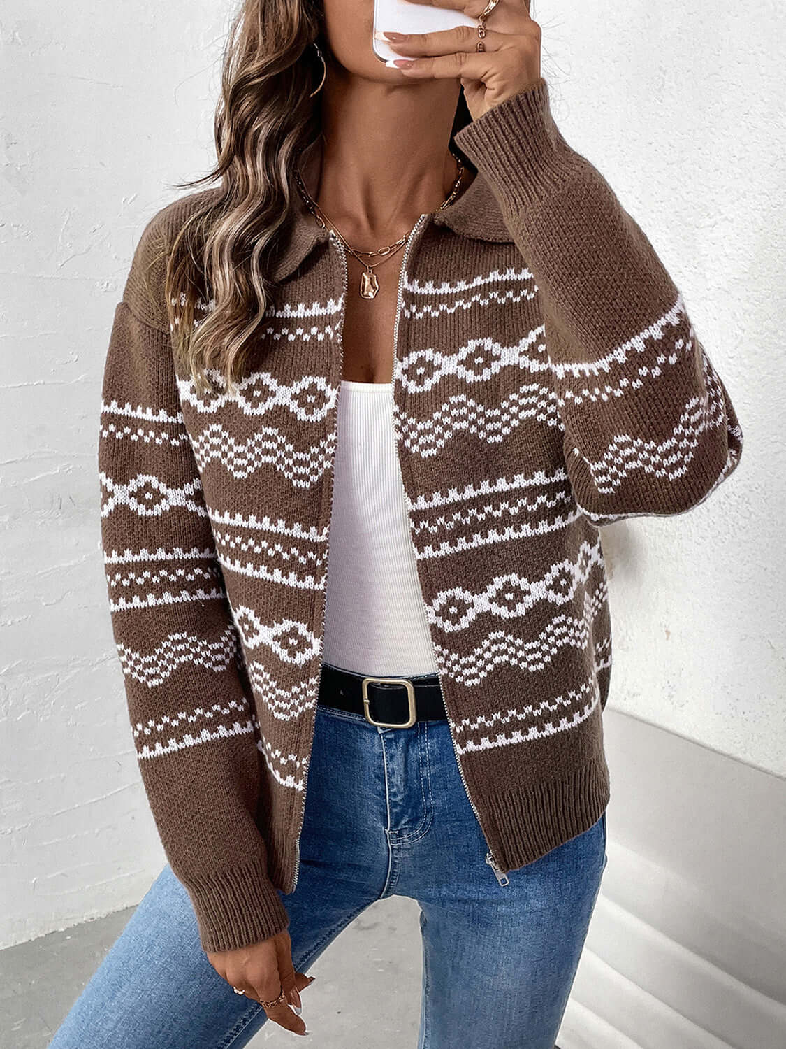 Woman wearing Perfee Geometric Zip Up Collared Neck Long Sleeve Cardigan in brown with white geometric design, paired with jeans and white top.