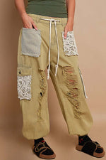 Distressed washed jeans with crochet patches, combining rugged and feminine styles for a trendy bohemian look.