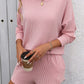 Woman wearing a stylish pink Double Take Round Neck Long Sleeve Top and Shorts Set, holding a coffee cup. Perfect for casual outings or lounging.