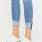 Distressed Cat's Whiskers Button Fly Jeans with rolled cuffs and white platform sneakers for a trendy casual look