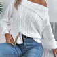 Woman wearing Bella Road Cable-Knit One Shoulder Long Sleeve Sweater in white paired with blue jeans.