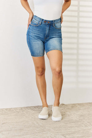 Woman wearing Tummy Control Double Button Bermuda Denim Shorts by Judy Blue Jeans, showcasing stylish and comfy full-size shorts.