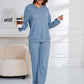 Woman in light blue Bella Road Dropped Shoulder Long Sleeve Hoodie and Pants Set, holding a coffee cup, looking stylish and relaxed.