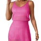 Woman wearing a vibrant pink openwork V-neck sleeveless cover up dress.