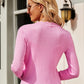 Woman wearing Bella Road Button Up Long Sleeve Cardigan in pink, showing back view with ribbed texture and stylish fit.