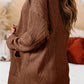 Woman wearing a textured open front cover up with pockets in brown, slightly stretchy fabric.