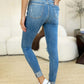 Back view of woman wearing Judy Blue Mid Rise Destroy & Cuff Skinny Jeans, showcasing cuffed hem and destroyed detailing.