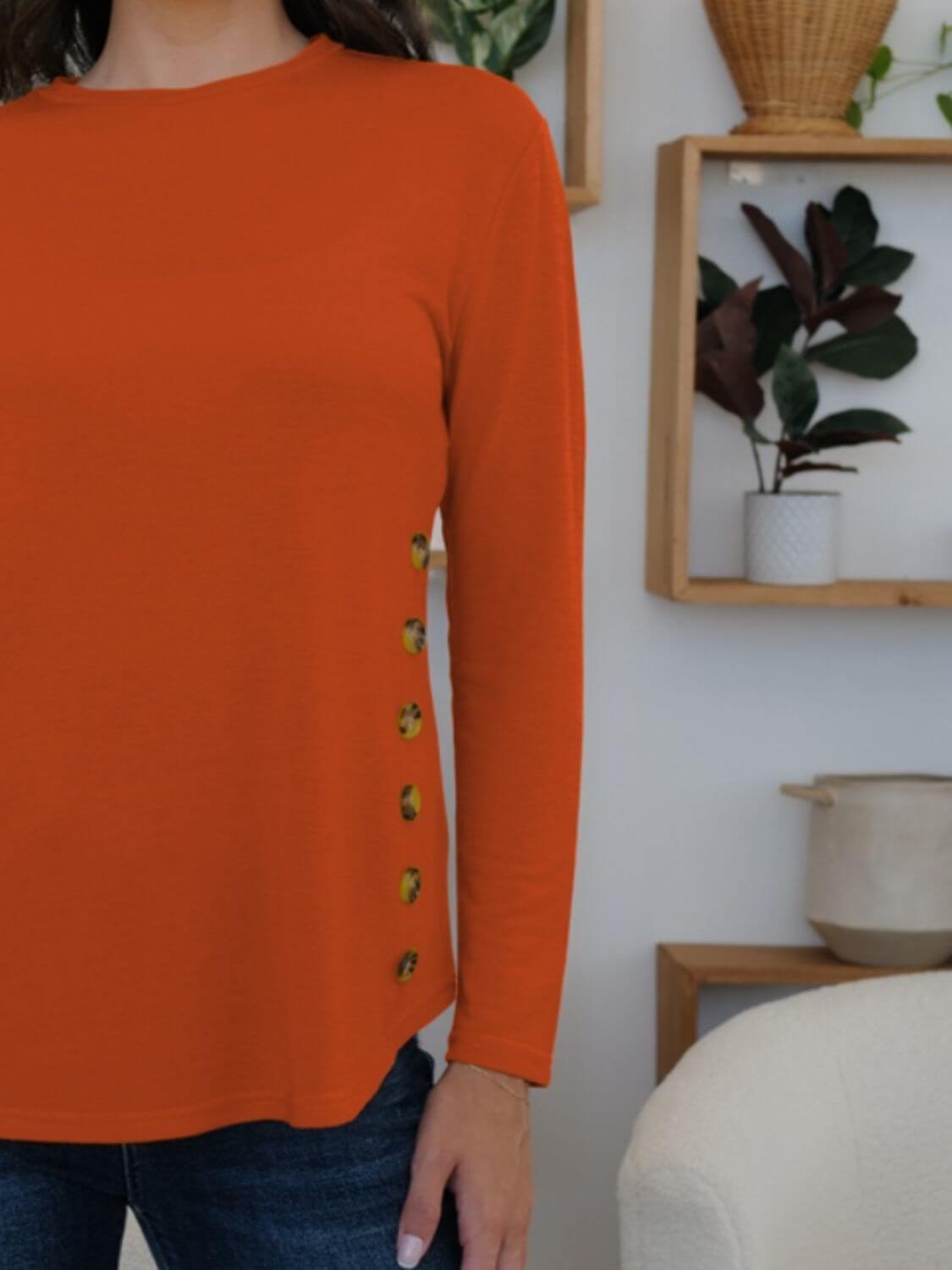 FAM-FAM round neck long sleeve t-shirt in orange with decorative side buttons, perfect for casual occasions and versatile style.