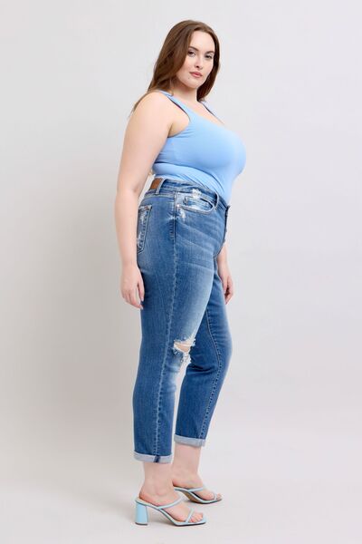 Judy Blue plus size button fly distressed jeans, showing stylish fit and practical pockets on a model in a blue tank top.